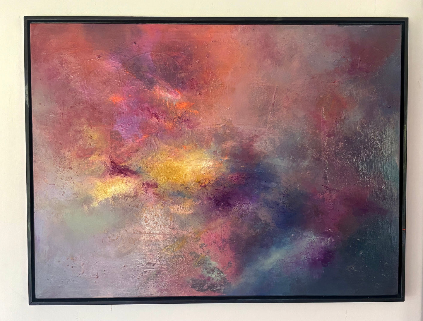 Abstract painting with vibrant colors on a white wall