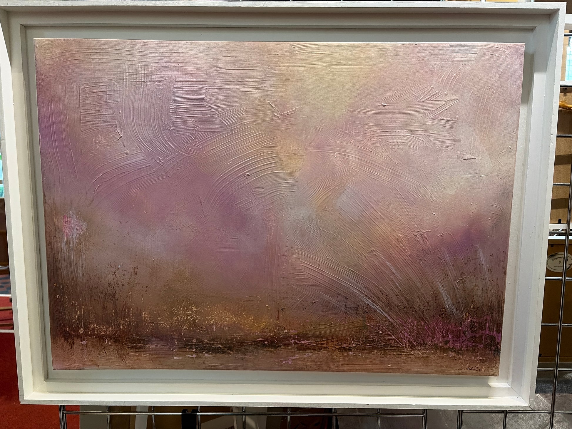 Framed abstract painting with a textured surface in soft colors.